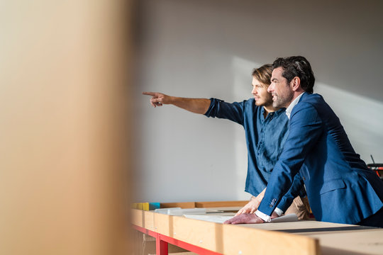 Businessman and employee talking at workbench