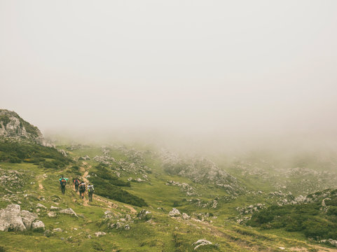 Spain, Cantabria, Group of backpackers hiking in Picos de Europa during foggy weather