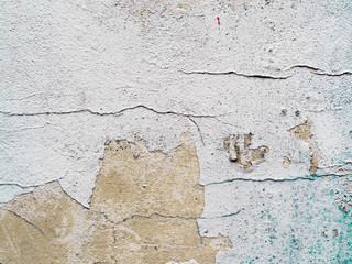light gray concrete painted wall with cracks, drops of red and blue paint . gray background