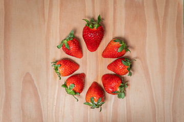 Collection set of photos of strawberries in a cirlce on wooden background for stop motion video clip. Juicy fresh vegan strawberry