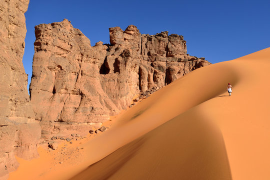 Algeria, Tassili n' Ajjer, Tadrart, Sahara, Tassili n' Ajjer National Park, woman walking on sand dune in of Moul Nag