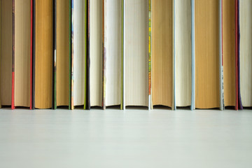 An even row of books close up on a white background and copy space