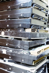 Pile of computer hard disks in recycling plant. Concept of electronic waste and management reuse recycle and recovery. Old E-waste device is ready for recycling.