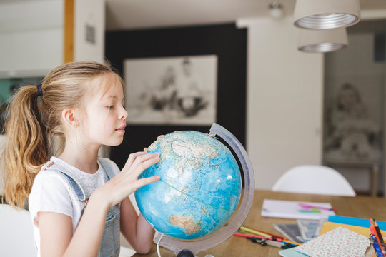 Girl looking at globe at home