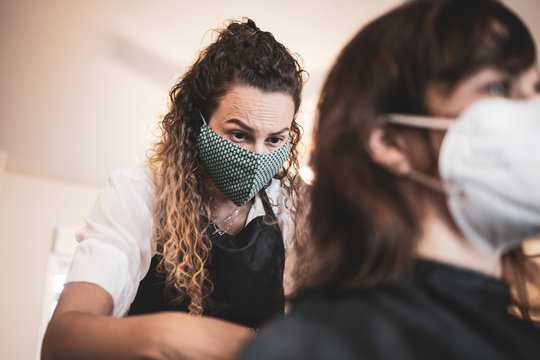 Hairdresser using face mask for the covid-19, new normality, social distance, hairdresser and client at client's home with mask cutting hair.