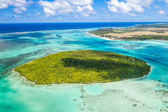 Lush vegetation on Ile aux Aigrettes atoll in the turquoise lagoon, aerial view by drone, Pointe d'Esny, Mahebourg, Mauritius, Indian Ocean, Africa