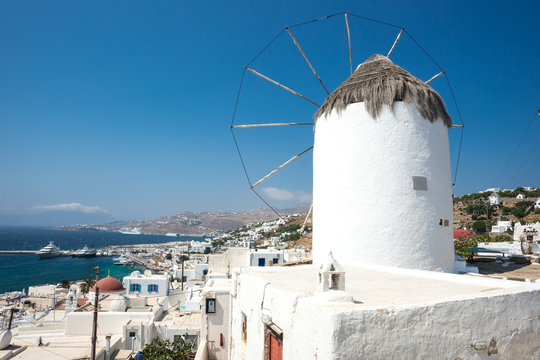 Nice view of the symbol of the Greek island of Mykonos - windmill on the background of the beautiful ocean and mountains