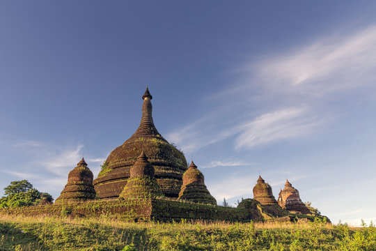 Looking up at the main stupa with satellite stupas of Andaw Thein pagoda with a few wispy clouds in a blue sky above, Mrauk U, Rakhine, Myanmar (Burma), Asia