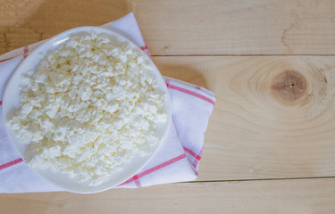 Dish of fresh cottage cheese on a wooden background. Healthly food. Fresh cottage cheese, rustic food. Organic cottage. Keto diet. View from above. Copyspace