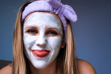 On the face of a beautiful girl a mask to moisturize the skin.