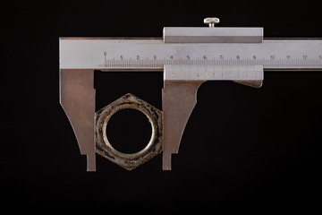 Measuring machine parts with an analog caliper. Measurement work in the workshop.