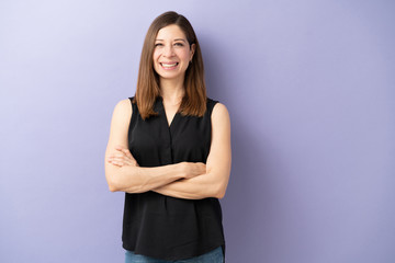 Obraz premium Friendly woman standing with arms crossed
