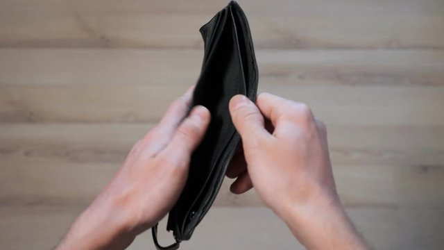 male hands open empty black wallet close up