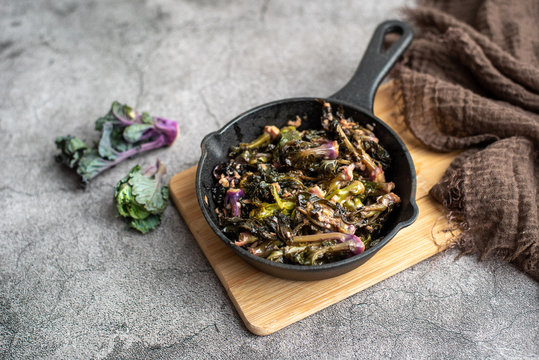 Saut&eacute;ed kalettes, cooked in butter and garlic in a cast iron pan.