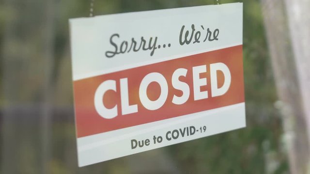 Closed sign hanging on the glass during pandemic time in 4K Slow motion 60fps