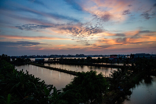 Vietnam, Cần Thơ, B&igrave;nh Thủy, Zu Besuch auf der Insel Con Son (Cồn Sơn, B&ugrave;i Hữu Nghĩa,) in der N&auml;he von Cần Thơ der gr&ouml;&szlig;te Stadt im Mekong-Delta und gleichzeitig die Hauptstadt des Mekong Delta. Wanderung zum Aussichtspunkt der Insel bei Sonnenuntergang. Blick &uuml;ber die Insel vom Aussichtspunkt., Begr&uuml;nte Wege mit Palmen im Fluss bei Sonnenuntergang