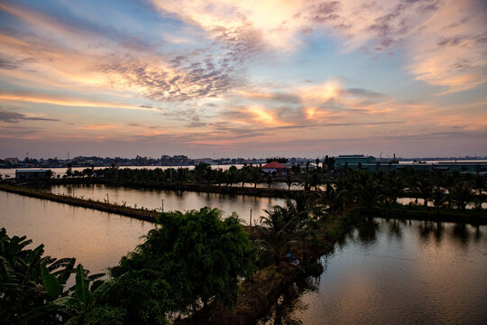 Vietnam, Cần Thơ, B&igrave;nh Thủy, Zu Besuch auf der Insel Con Son (Cồn Sơn, B&ugrave;i Hữu Nghĩa,) in der N&auml;he von Cần Thơ der gr&ouml;&szlig;te Stadt im Mekong-Delta und gleichzeitig die Hauptstadt des Mekong Delta. Wanderung zum Aussichtspunkt der Insel bei Sonnenuntergang. Blick &uuml;ber die Insel vom Aussichtspunkt., Begr&uuml;nte Wege mit Palmen im Fluss bei Sonnenuntergang