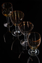 Group of four different glasses with nice reflection on black backdrop