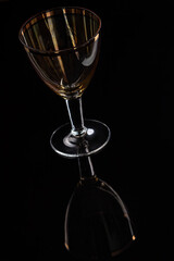 One yellow glass on the black backdrop with nice reflection