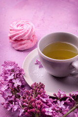 Cup of tea, homemade marshmallow and lilac. Romantic spring. Selective focus