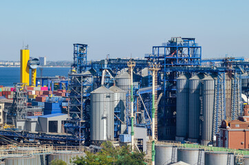 Obraz premium Granary with containers for storage and loading of grain in the seaport. Grain transportation, agribusiness