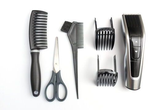 Hairdressing accessories: clipper, scissors, combs on a white background.