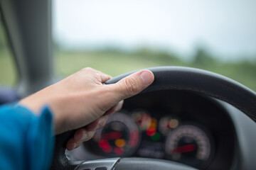 Man holding hand on steering wheel
