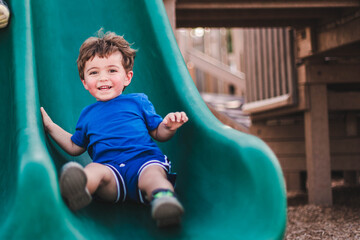 Fototapeta na wymiar boy on playground slide in marco island mackle park 