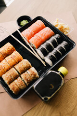 Freshly cooked sushi chef, delicious big rolls with avocado, cheese, salmon, sesame seeds 