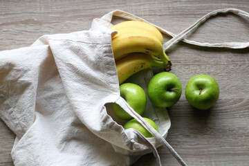Canvas tote bag with apples and bananas. Top view.