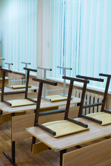 A fragment of an empty classroom at school - with desks and overturned chairs