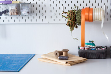 working sewing tools on the wall and table in the tailor's workshop in the atelier, the sewing workshop. scissors, needles, threads, ribbons, boxes with accessories. sewing accessories