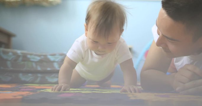 Father helping his baby girl to crawl in a home setting. 