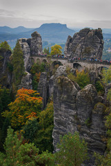Fototapeta na wymiar The Bastei stone bridge in the Saxon Switzerland National Park near Dresden, Germany on a foggy autumn day.