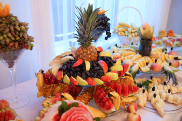 Table with delicious sweets and Candy bar with strawberries and pineapple.