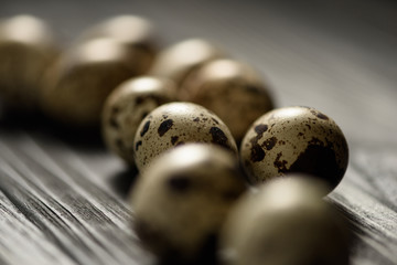 Closeup quail eggs with selective focus on black wooden background