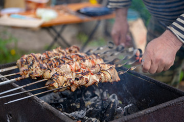 Close up of toasted shashlik on skewers. Succulent barbecue roasting on chargrill. Concept of picnic outdoor.