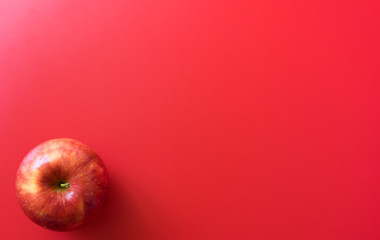 Red apples on a red background. Flat lay, top view