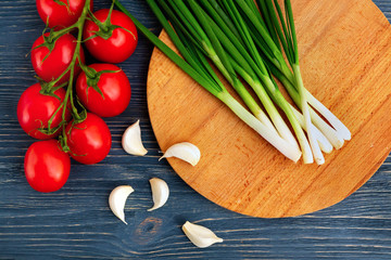 Vegetables, tomatoes garlic and onions, on an old rustic wooden table