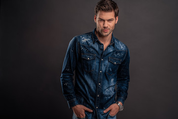 Modern and casual. handsome young man looking at camera with smile while standing against white background