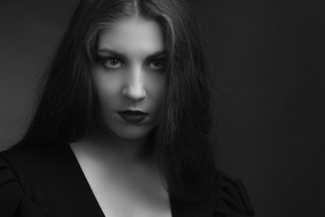 Fototapeta premium Black and white portrait of young fat girls brunette with long hairblack dress with sweetheart neckline