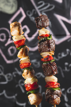 Espetinhos de carne e frango com legumes assado no boteco