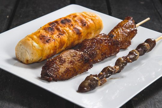 Espetinhos assados de frango asa ou tulipa, cora&ccedil;&atilde;o de frango com p&atilde;o de alho assado servido em prato no boteco