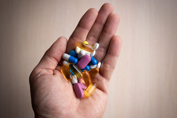 colorful tablets and capsules in the palm of your hand
