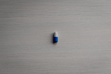blue and white capsule on a gray background health