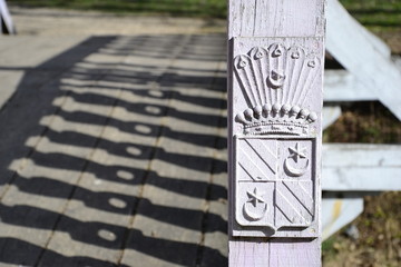 Hutten-Czapsky coat of arms on wooden bridge fence. Stankovo. Belarus.