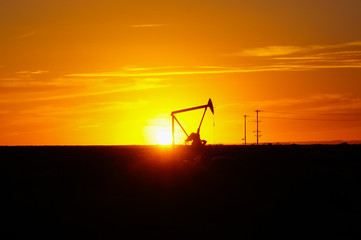 Silhouette Oil pumps at oil field with sunset sky background