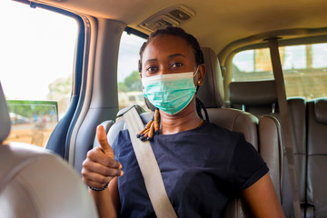 young black beautiful woman sitting in a car and wearing a nose mask