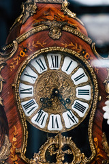 Vieille horloge en bois et dorures au style baroque