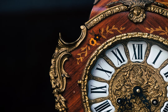 Vieille horloge en bois et dorures au style baroque